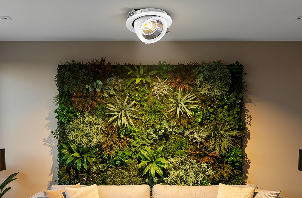 Spot LED encastré illuminant un mur végétal stabilisé dans un salon moderne.